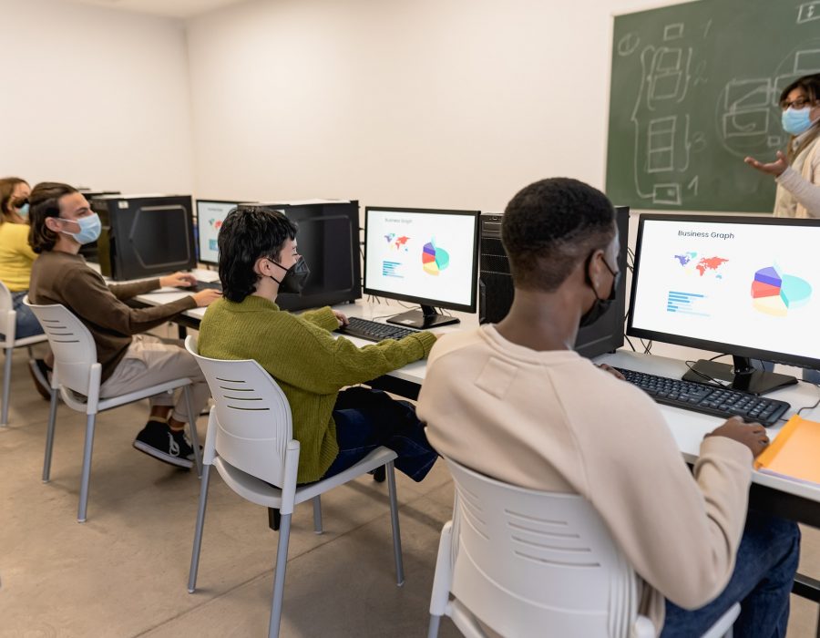 Young students listening a lesson in high school while wearing face mask during corona virus